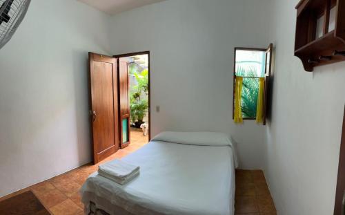 Un dormitorio con una cama y una puerta de madera. en Casa Romano Hostel, en San Juan del Sur