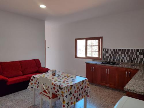 a living room with a table and a red couch at Victoria 2 in Tejeda