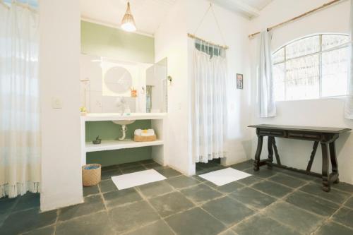 a bathroom with a table and a sink at Villa Ostello in Paripueira
