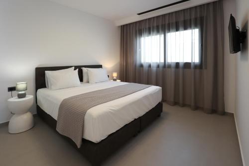 a bedroom with a large bed and a window at LIMI Deluxe Suites in Kokkíni Khánion