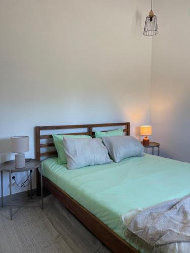 a bedroom with a bed with green sheets and pillows at Monte da Lua in Montargil