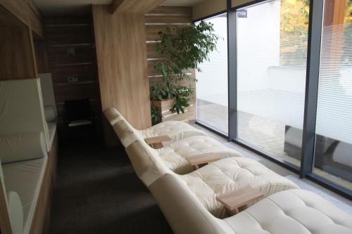 a room with a white couch and a large window at Apartmán ve Vysokých Tatrách in Štrbské Pleso