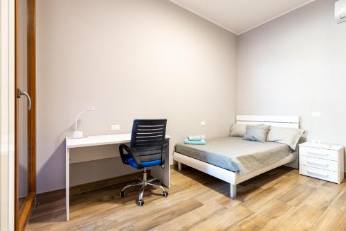 a bedroom with a bed and a desk and a chair at Relis rooms in Quartu SantʼElena