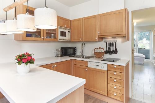 a kitchen with wooden cabinets and a white counter top at Gästehaus Herma in Ramsau am Dachstein