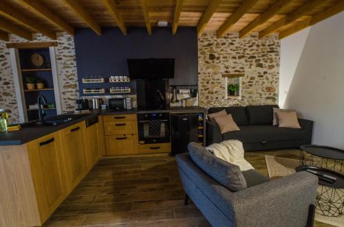a kitchen and living room with a couch and a table at Le Petit Candie in Maisoncelles-en-Brie