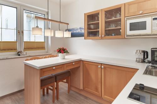 a kitchen with wooden cabinets and white countertops at Gästehaus Herma in Ramsau am Dachstein
