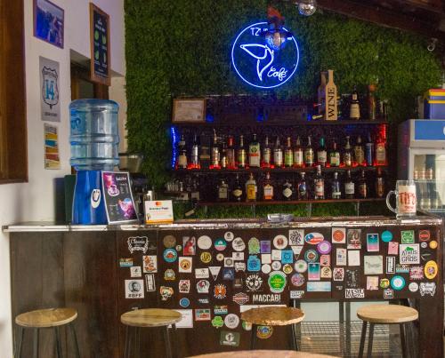 a bar with a lot of stickers on the wall at Tzunun Hostel in Antigua Guatemala