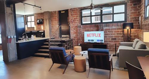 a living room with a brick wall and a table and chairs at The Maverick, powered by Placemakr - River Walk in San Antonio