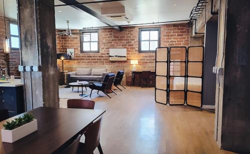 a loft with a brick wall and a table and chairs at The Maverick, powered by Placemakr - River Walk in San Antonio