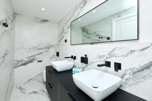 a white bathroom with a sink and a mirror at TUDISI LUX SUITES by DOMINIUM in Dubrovnik