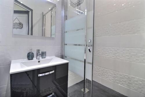 un bagno bianco con lavandino e doccia di Logement au pied de la gare ad Aulnay-sous-Bois
