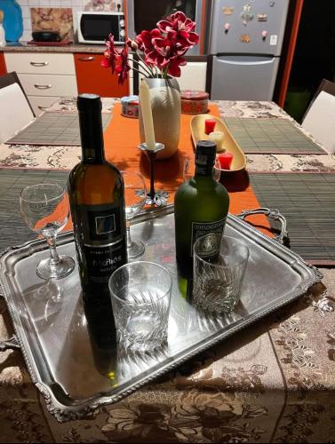 a tray with two bottles and glasses on a table at Αναστασία in Diakopto