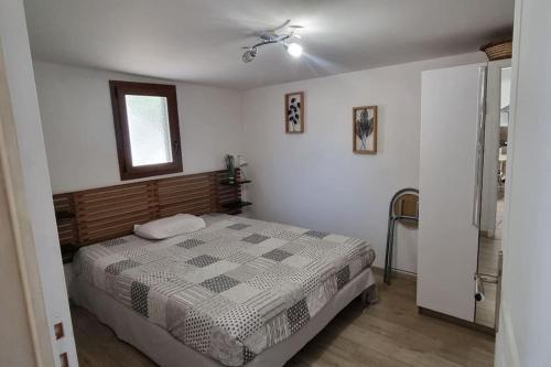 une chambre avec un lit et un ventilateur de plafond dans l'établissement Maisonnette chez l'habitant, à La Ciotat
