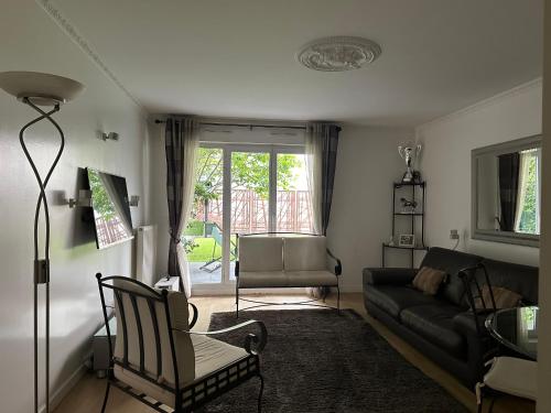 un salon avec un canapé et une chaise dans l'établissement Maison parisienne, à La Garenne-Colombes