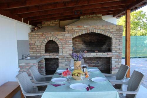a table and chairs with a brick fireplace at Crystal pool in Bihać