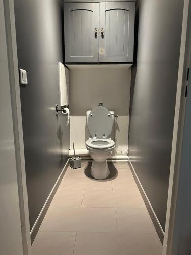 - une salle de bains avec des toilettes blanches dans une cabine dans l'établissement Maison parisienne, à La Garenne-Colombes