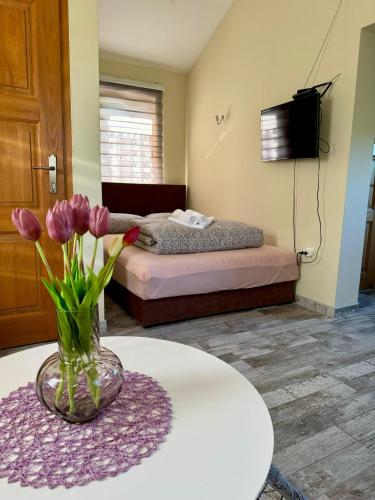 a room with a bed and a vase of flowers on a table at Crystal pool in Bihać