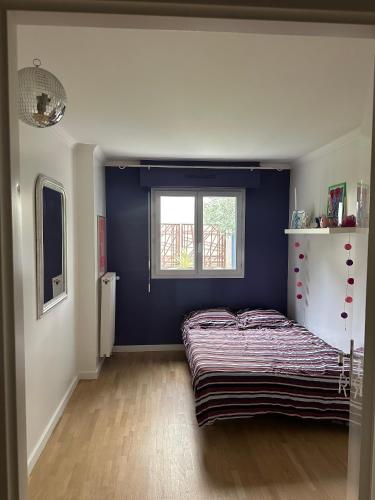 une chambre avec un lit et une fenêtre dans l'établissement Maison parisienne, à La Garenne-Colombes