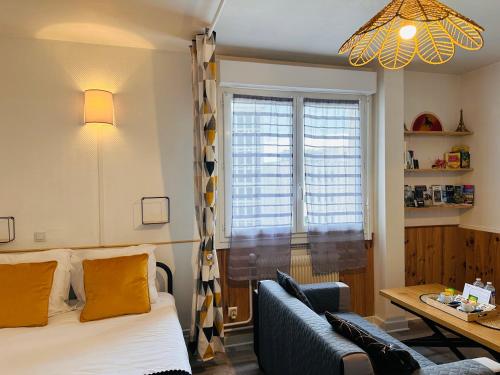 une chambre avec un lit, un canapé et une fenêtre dans l'établissement ORLEANS CENTRE PROCHE GARE - Appartement fonctionnel Résidence calme Parking privé gratuit - LE CENTRAL ELEGANCE, à Orléans