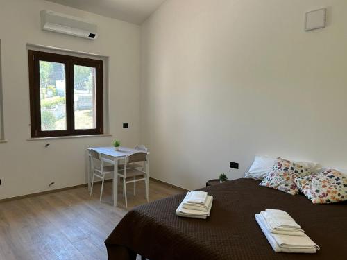 a bedroom with a bed and a table and a window at Green Residence Villa Assunta in Moscufo