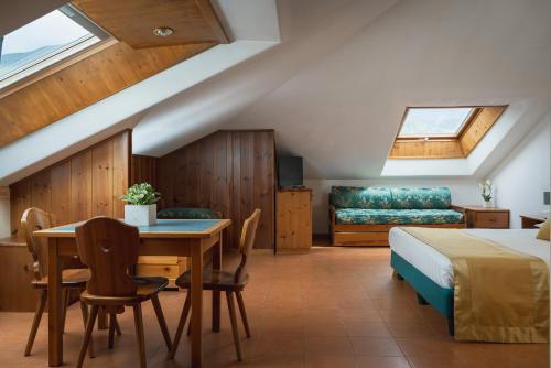 a bedroom with a bed and a table and chairs at Hotel Cristallo in Bormio