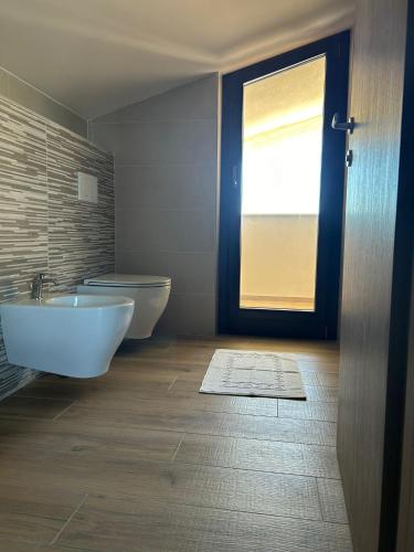 a bathroom with two sinks and a door with a window at Green Residence Villa Assunta in Moscufo