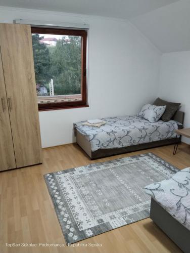 a living room with two beds and a window at Topsan Prenociste Rooms in Sokolac