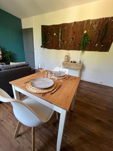 une table de salle à manger avec des verres à vin dessus dans l'établissement Le petit jardin de Bellune, à Niort
