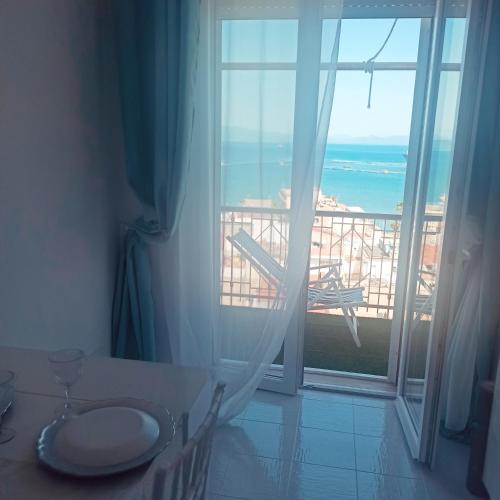 a room with a table and a view of the ocean at Blue Eyes L'INCANTESIMO SUL MARE in Gaeta