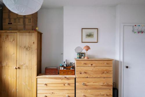 una camera da letto con cassettiera e cassettiera in legno di Comfy 1-Bed Flat Near Hospital & Station a Londra