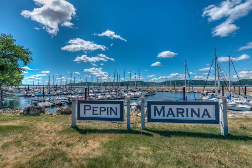 two signs in front of a marina with boats at Starshine Condo - 2 Minute Walk to the Beach! in Pepin
