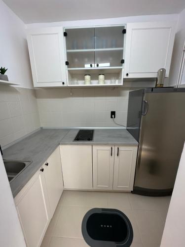 a kitchen with white cabinets and a stainless steel refrigerator at Banovo Brdo Premium in Čukarica