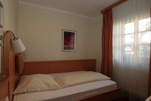 a small bed in a bedroom with a window at Landgasthof Drei Rosen in Bernried