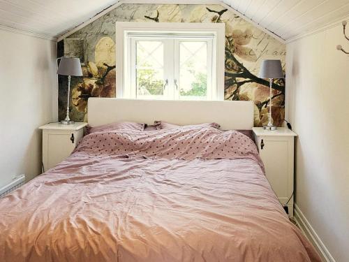 a bedroom with a large bed with a window at 4 star holiday home in TJÖRN in Almösund
