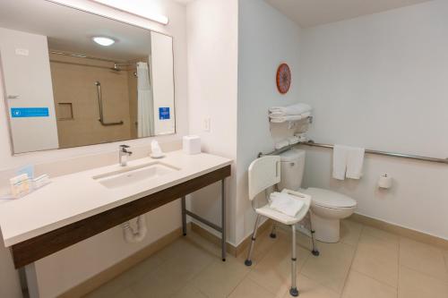 a bathroom with a sink and a toilet and a mirror at Hampton By Hilton San Jose Airport Costa Rica in Alajuela City