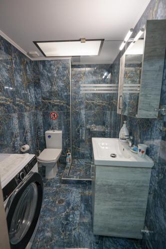 a bathroom with a sink and a washing machine at Maria's Home in Kanallákion
