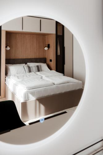 a bedroom with a large white bed in a mirror at Atelier 51 - Free parking in Mostar