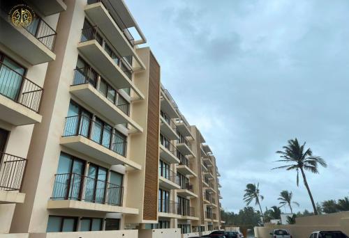 an apartment building with a palm tree in the background at Departamento Puerta al Mar, Veracruz in Conchal