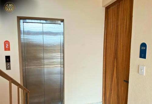 a metal elevator in a room with a staircase at Departamento Puerta al Mar, Veracruz in Conchal