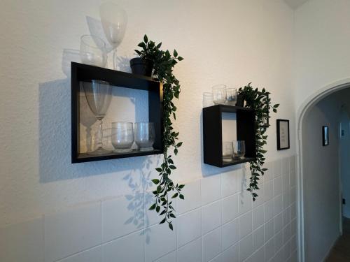 a bathroom with two mirrors and plants on the wall at Zentrale Wohnung in Koblenz