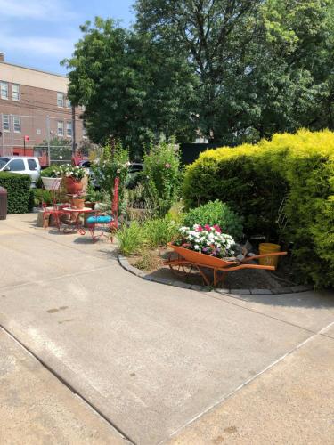 a garden with benches and flowers on a sidewalk at Private Unit - Shared Public Space in South Ozone Park
