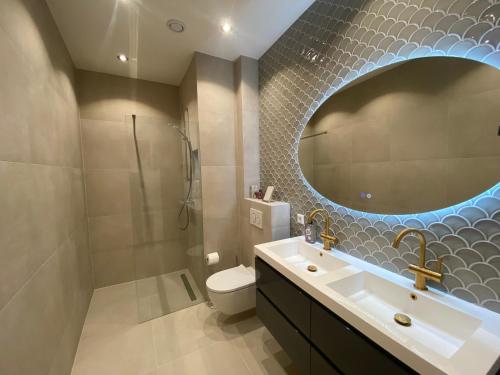 a bathroom with a sink and a toilet and a mirror at Goodnight Amsterdam Lovely B&B in city centre-private-quiet-luxurious in Amsterdam