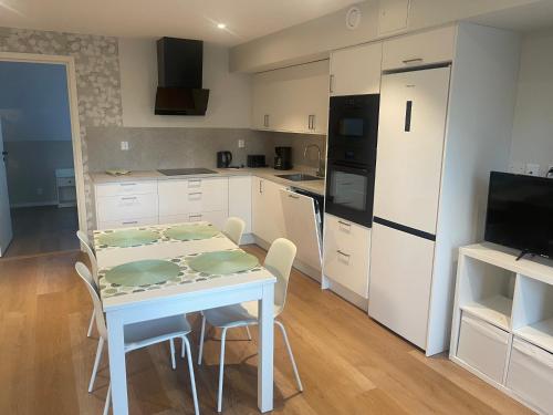 a kitchen with a table and chairs and a refrigerator at Rådjursstigen 2A Vimmerby in Vimmerby