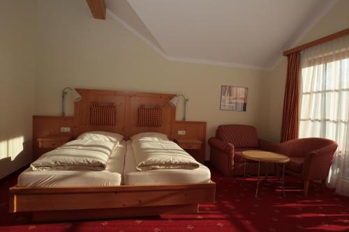 a bedroom with a bed and a table and chairs at Landgasthof Drei Rosen in Bernried