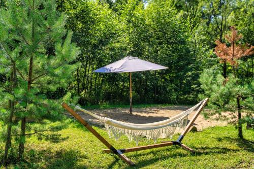 a hammock and an umbrella in a garden at Tarninowe Wzgórze in Kunkowa