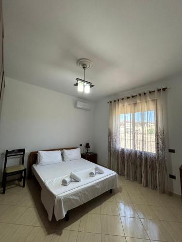 a bedroom with a large bed and a window at Villa Bordeaux in Rrashbull