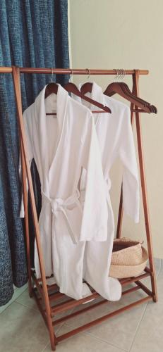 a wooden clothes rack with white clothes on it at Zoes House in Kyra Panagia