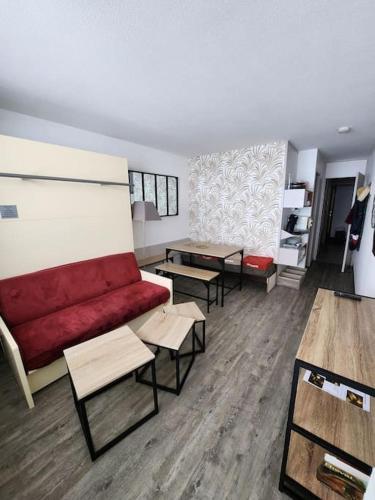 - un salon avec un canapé rouge et des tables dans l'établissement Appartement 