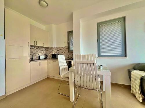una cucina con due sedie e un tavolo in una stanza di Acacia hill B6 a Ðenovići
