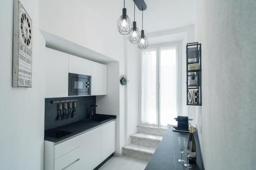 a white kitchen with a table and a window at Carlo's FN66 - nel Cuore di Sanremo - in Sanremo